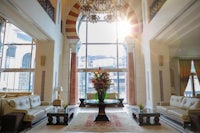 the lobby of a hotel with large windows and a chandelier