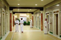 a group of men are standing in a hallway