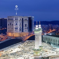 an aerial view of a city at night with a mosque in the background