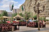 a large outdoor area with tables and chairs in front of a mountain