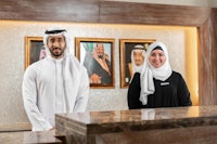 a man and woman standing in front of a reception desk