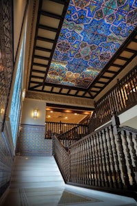 an ornate staircase with a tiled ceiling